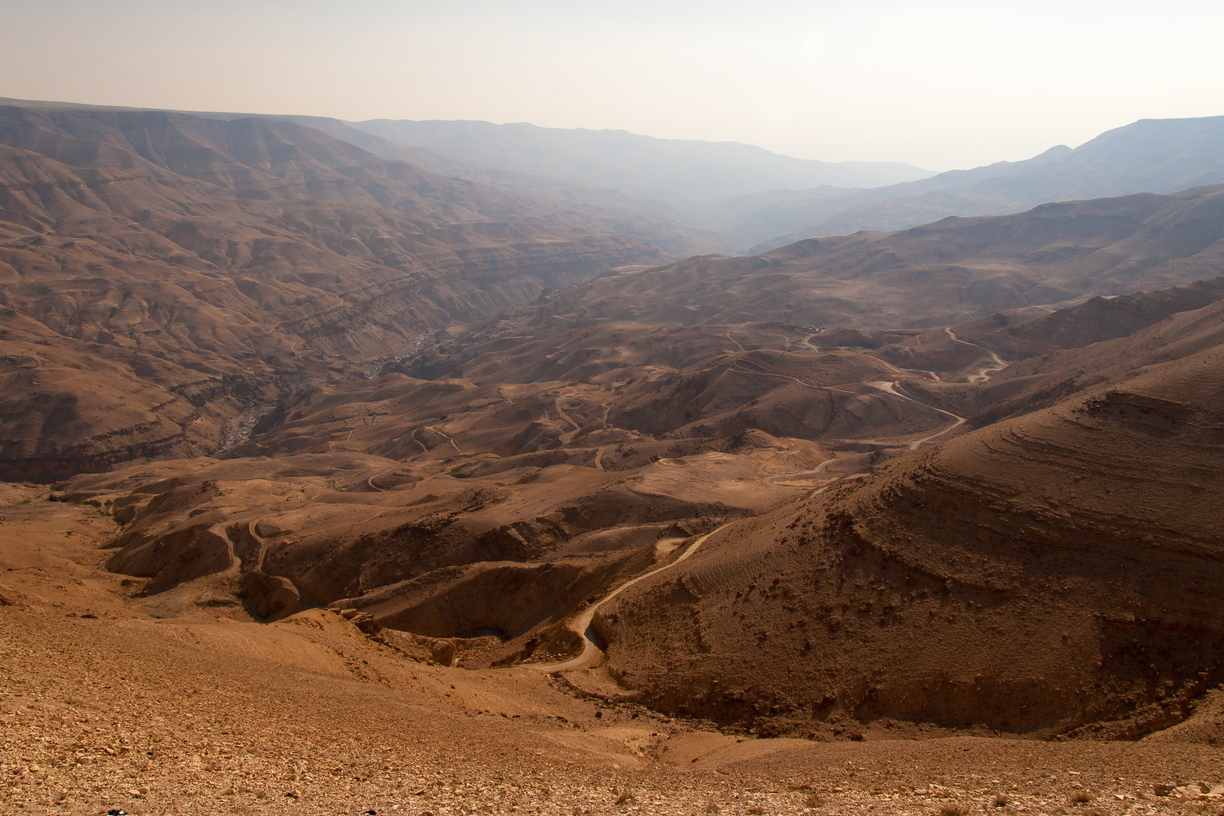 Wadi Mujib, a huge canyon system in Jordan, traced by rivers and road structures.